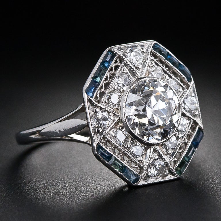 A strikingly beautiful Art Deco diamond ring featuring a bright-white and brilliant European-cut diamond weighing 1.28 carats. The center diamond is presented with consummate and sophisticated Art Deco geometry in a superlative hexagonal-shape