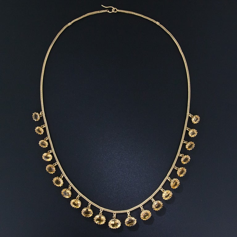 Twenty-one faceted golden citrines dance and glisten below a lithe and supple 14 karat gold mesh chain for an enchanting mono-chromatic effect, in this extra-lovely late-nineteenth/very early-twentieth century necklace. Each faceted citrine is