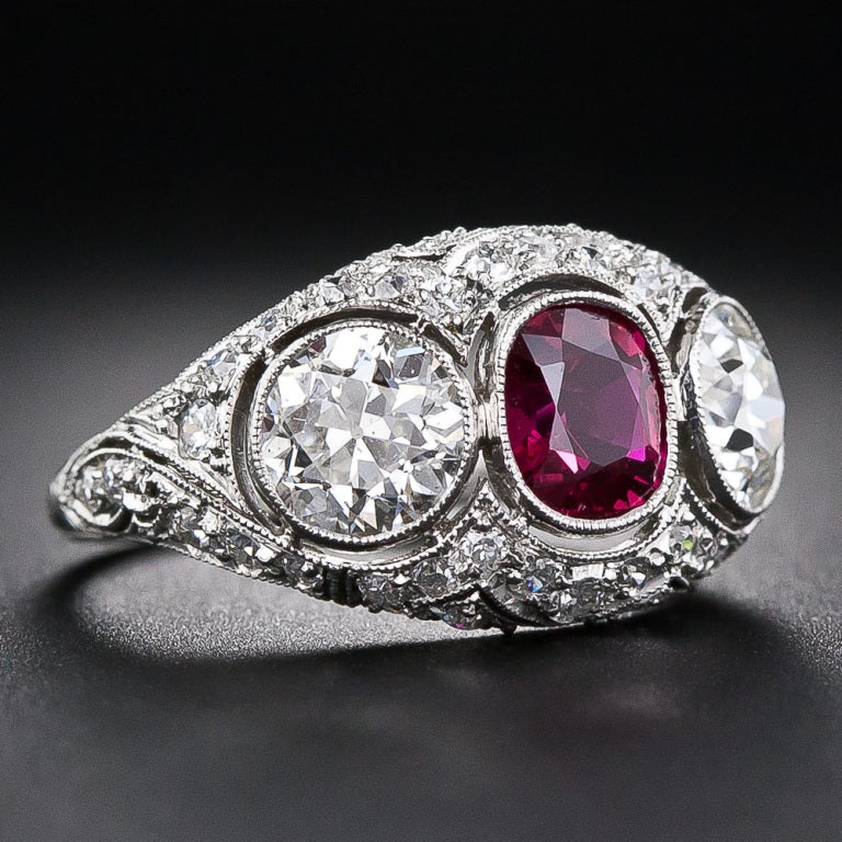 Few come finer than this ravishing ruby and diamond ring, exquisitely crafted in platinum. This gemmy vintage style jewel centers on a bright, deep-red, oval cushion-cut ruby of Siam (Thai) origin, weighing one carat. The gorgeous gemstone rubs