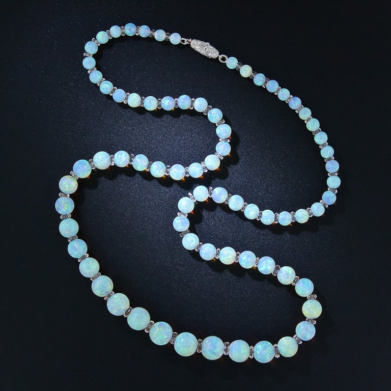 A glowingly gorgeous, superior quality opal bead necklace composed of seventy-three multi-chromatic beads, ranging from 4 millimeters to 7.8 millimeters, separated by faceted quartz rondelles. The opals display an enchanting and consistent palette