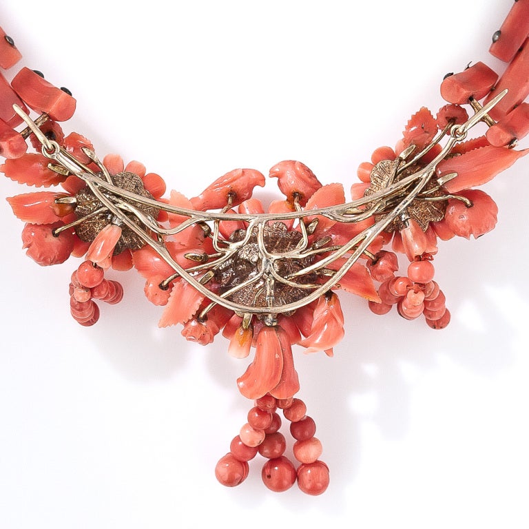 From mid-nineteenth century Italy comes this extraordinary carved coral necklace. The centerpiece is comprised of three flower blossoms, each of which is composed of individually hand carved petals and leaves, only three of which are missing. The