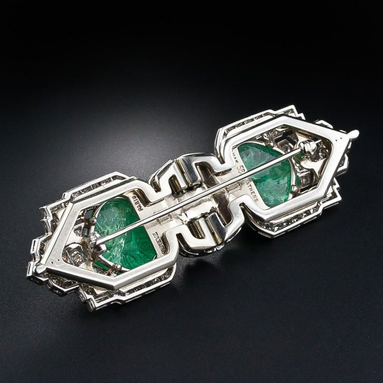 A sensational and striking pair of platinum, diamond and carved emerald dress clips and brooch combo dating from the zenith of the Art Deco period - circa 1925. An exotic pair of lozenge-shape carved emeralds, together weighing about 16.00 carats,