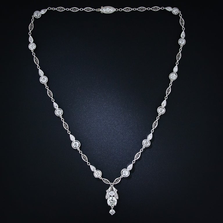 A fabulous and fanciful 17 inch-long diamond necklace culminating in a bright and beautiful 1.75 carat European-cut diamond. This stunning sparkler features twelve larger European-cut diamonds (not including the center stone) framed in 'compass'