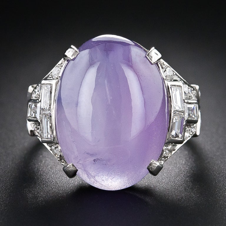 An enchanting and exotically colored lavender star sapphire, weighing 18.50 carats and fashioned by a masterful lapidary to present considerably larger, is presented in consummate and sophisticated Art Deco glory in this magnificent and unique