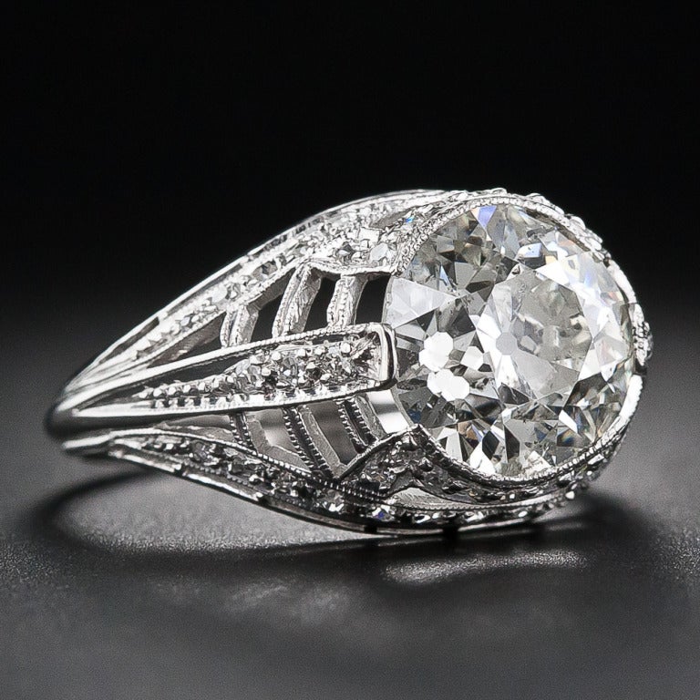 This dynamic and highly distinctive diamond ring, crafted in platinum, features a dazzling 3.17 carat European-cut diamond. This radiant rock is embraced top and bottom by sparkling diamond-set half bezels and left and right by sleek diamond-set