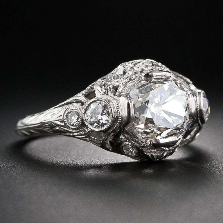 A beautiful 2.02 carat antique cushion-cut diamond scintillates in the center of this early-twentieth century engagement ring, hand fabricated in platinum with masterful decorative openwork details. The sparkling center stone is surrounded by ten