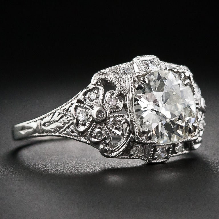 This sparkling sensation, crafted in platinum and diamonds - circa 1920s-30s, radiates front and center with a blazing 1.77 carat old European-cut diamond. The stunning stone is nestled atop an elegantly styled Art Deco mounting adorned all around