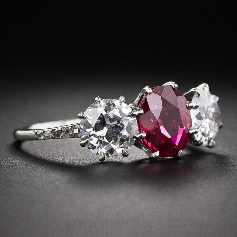 A gorgeous, deeply saturated, rich red ruby, weighing 1.74 carats, is accompanied by a bright-white pair of matching European-cut diamonds - together weighing 1.52 carats (.75 and .77 respectively) - in this superb and stunning classic three-stone