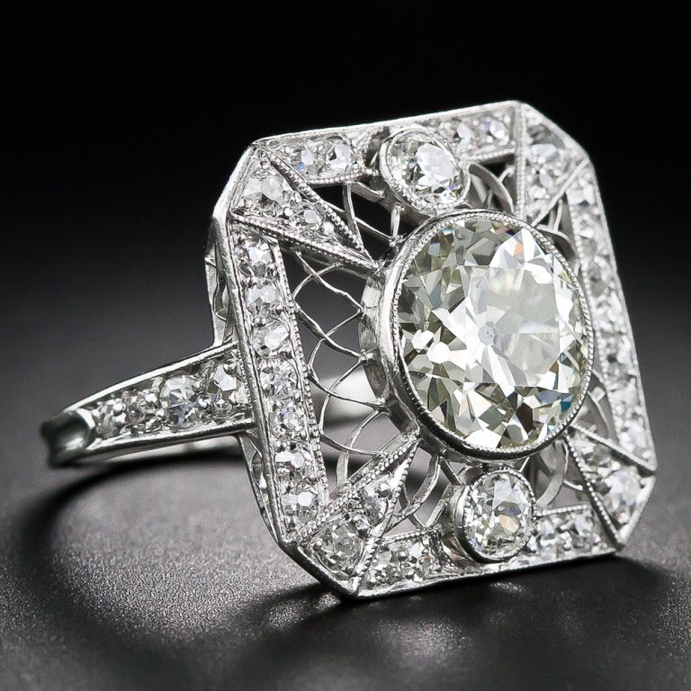 This early-nineteenth century Edwardian knockout shines front and center with a super-scintillating European-cut diamond, weighing 2.20 carats. The gorgeous center diamond sparkles from within a platinum bezel setting atop delicate Spirograph-style