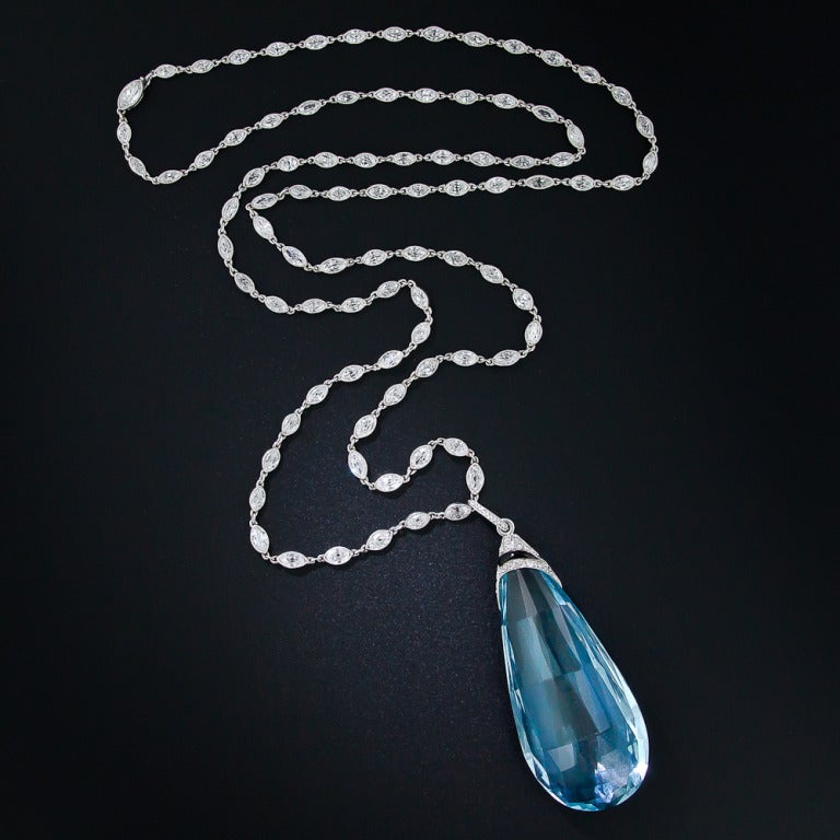 A truly spectacular, original early-Art Deco pendant necklace - circa 1920 - featuring a gorgeous, cool Caribbean-blue briolette aquamarine measuring 2-inches-long and weighing 80(!) carats. The rare and radiant gemstone is crowned with a