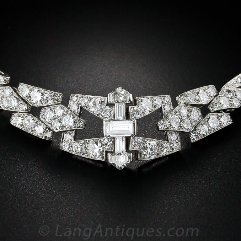 A stunning and sophisticated original Art Deco choker necklace from the zenith of the design period - circa 1925. The gracefully curved design centers on a geometric arrangement of three baguette diamonds and a pair of fancy shield-shape diamonds