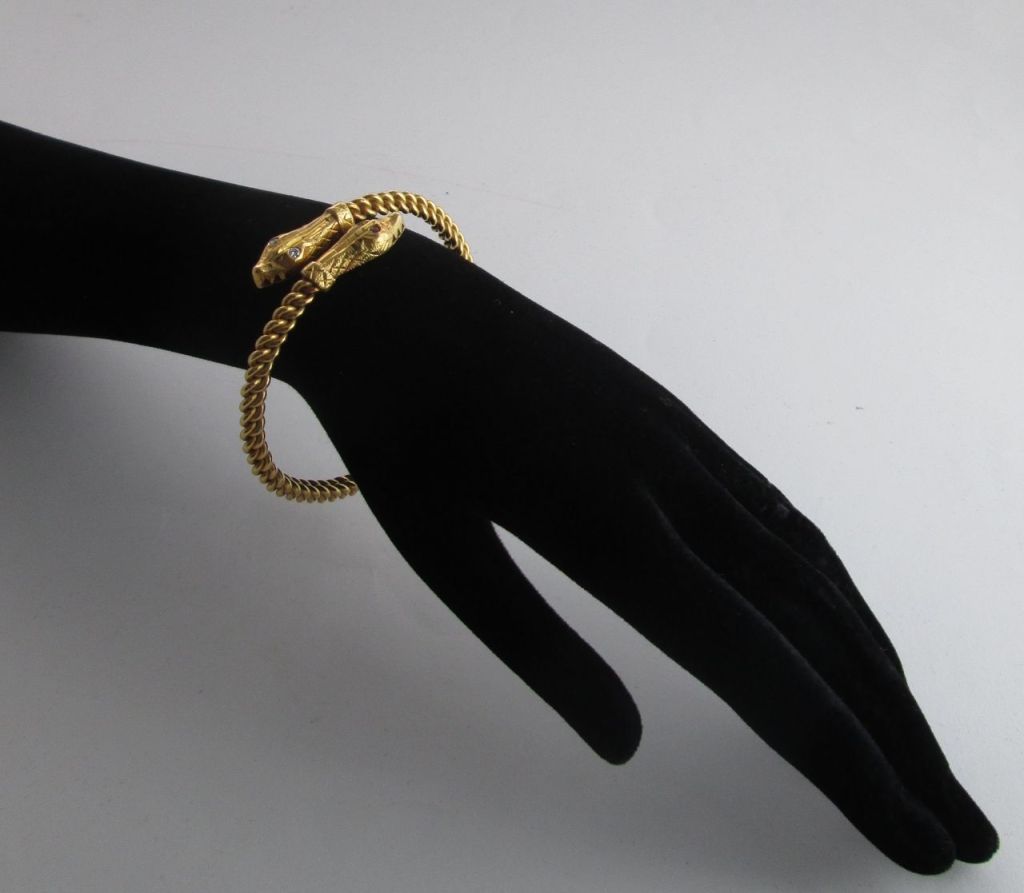 The two entwined snakes with ruby and diamond eyes to the hinged bangle, circa 1870, 7.5 cm. wide