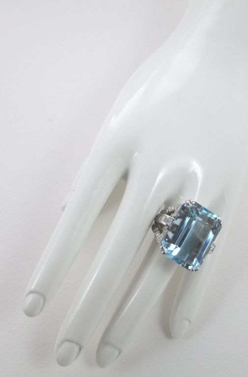 Claw-set with a step-cut aquamarine weighing 35.40 carats, within a brilliant-cut and baguette diamond shoulder weighing 1.81 carats, mounted in white gold

Size 7

Weight: 22.7 gr