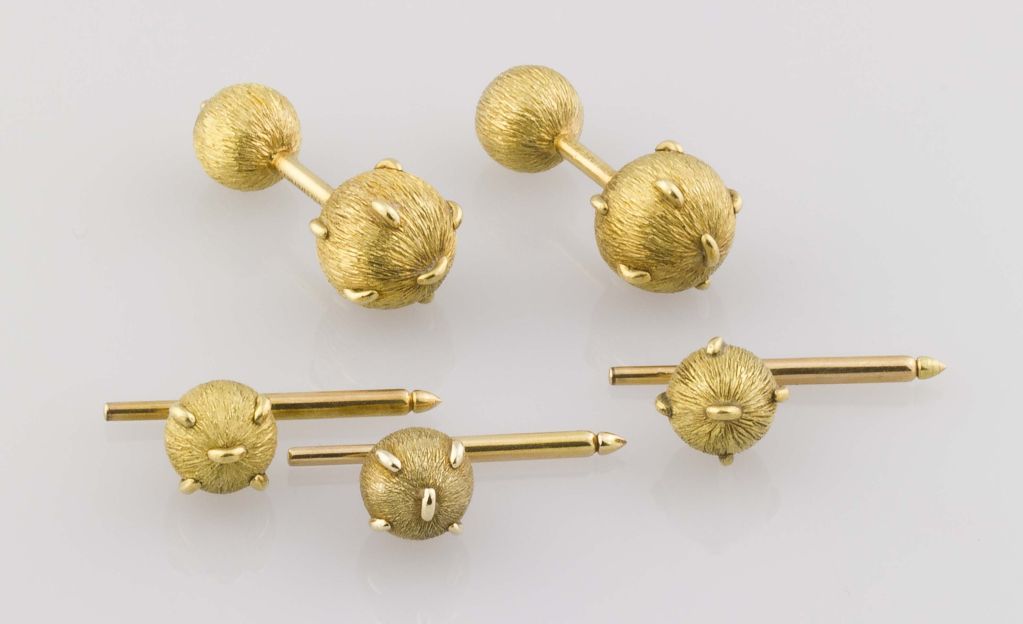 old and handsome 18k yellow gold cufflink and stud set, by Jean Schlumberger for Tiffany & Co. circa 1970s.  The cufflinks and studs are designed as spheres of Florentine satin like finish studded with polished gold bits.  The studs are 18k gold