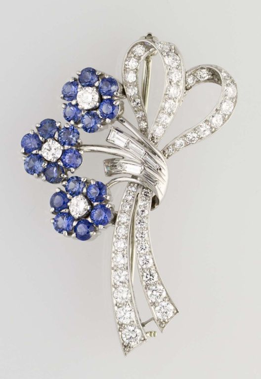 Vibrant and charming estate platinum set sapphire and diamond brooch clip designed as a bouquet of flowers, by Raymond Yard. It features approx. 2.0 cts of very high grade sapphires (very rich and lively blue) and approx. 1.75 cts of high grade