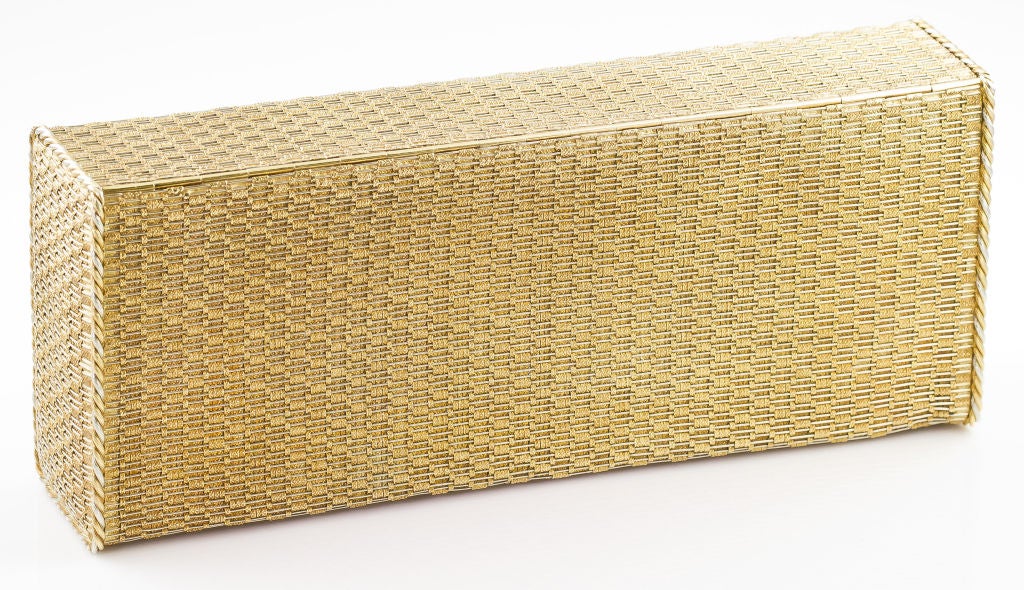 Chic estate clutch purse by Cartier, circa 1950s-60s. It features an engine turned basketweave design of white and yellow gold, with two tone twisted rope accents as borders. Purse also features a sapphire and diamond bar that is set in platinum,