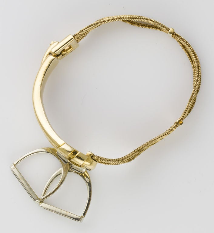 Very rare and unusual French estate two tone 18K gold stirrup bracelet by Hermes, circa 1960s-70s. A characteristic estate equestrian motif, with both fixed and moving parts. The fixed part resembles a loop with two stirrups of yellow and white gold