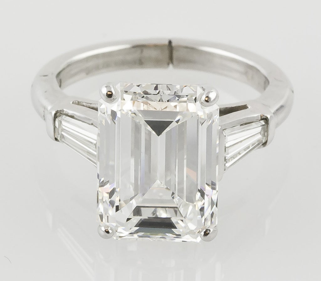 Important platinum and emerald cut diamond engagement ring. It features a 7.29cts H-VVS1 diamond featuring Very Good polish, Very Good symmetry, and faint florescence. Also features approx. 0.80cts of tapered baguette-cut diamonds of complimentary