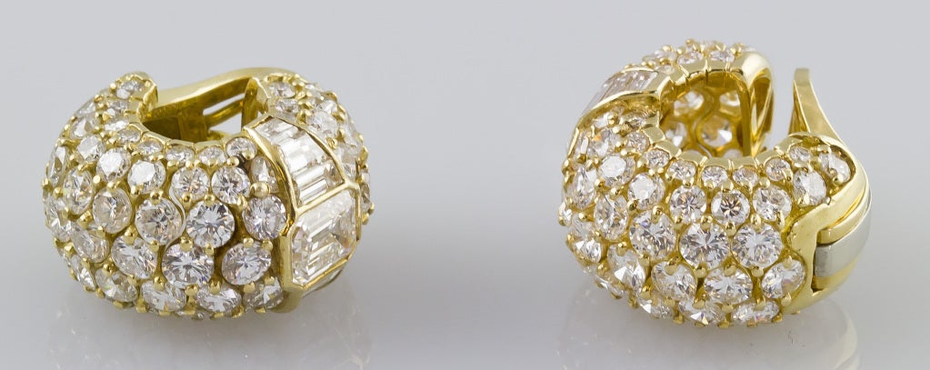 Bold and important 18K gold and diamond hoop shaped ear clips by Bulgari, made in France. They feature very high grade emerald cut diamonds of 1.07cts and 1.44cts respectively. ; surrounding these emerald-cut diamonds are both round brilliant cut