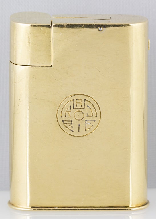 Very rare and fine 18K yellow gold watch lighter by Cartier, with European Watch & Clock (EWC) movement, circa 1930s. It features a manual wind movement.
Hallmarks: Cartier (on dial), maker's mark, French 18K gold assay mark, reference numbers.
