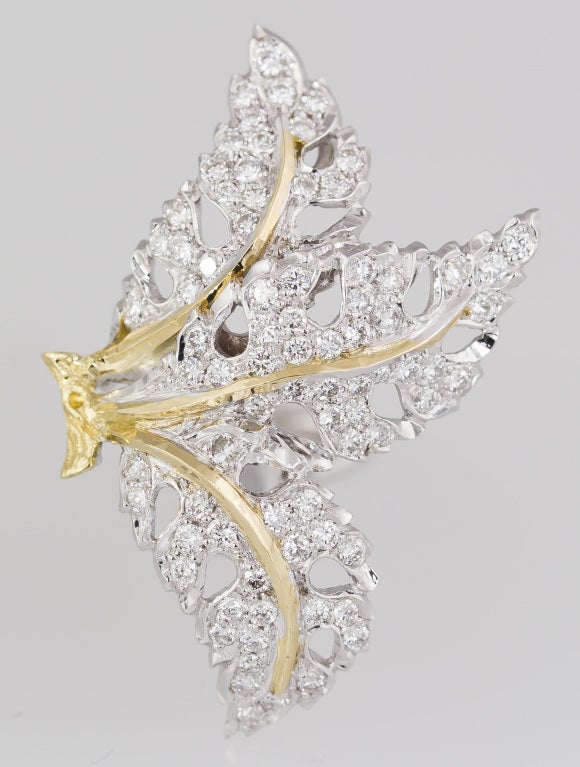 Intricate and unusual 18K white and yellow gold diamond earrings by Mario Buccellati. They feature the likeness of 3 leaves with yellow gold stems and high grade round brilliant cut diamonds adoring the bodies of the leaves throughout. The earrings