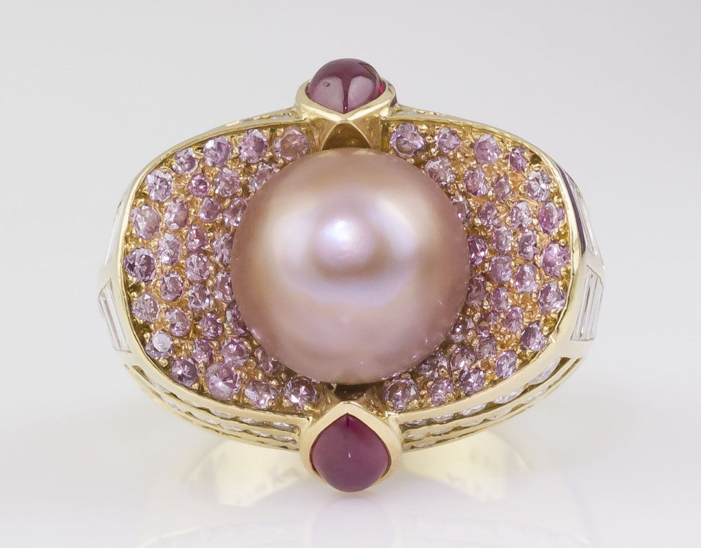 Rare and magnificent natural pearl ring by Mauboussin, complimented by pink & white diamonds, as well as rubies. The focal point is the natural pearl, which is button shaped, orangy pink in color, and approx. 7.61cts (with corresponding GIA