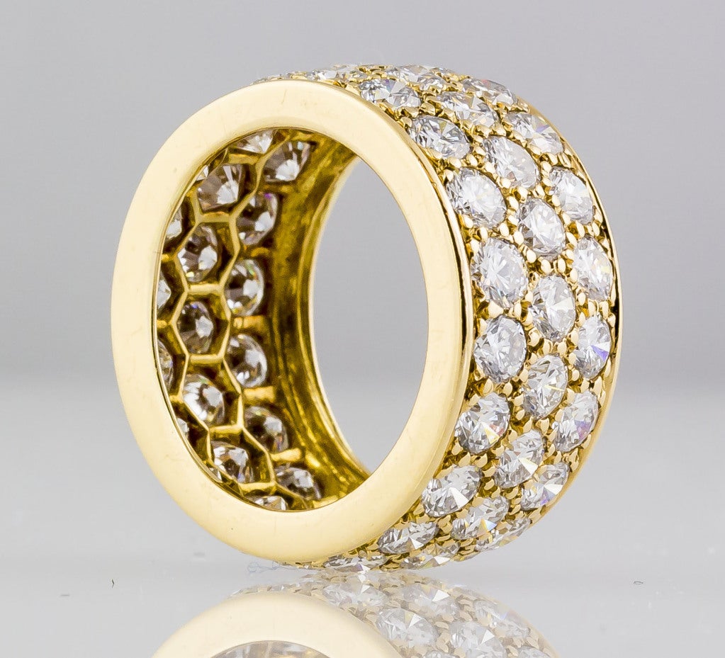 Classic and refined 18K yellow gold and diamond band by Oscar Heyman. It features three rows of approx. 6.5-7.0cts of high quality round brilliant cut diamonds.
Hallmarks:   O.H. hallmark, 18K, reference numbers.