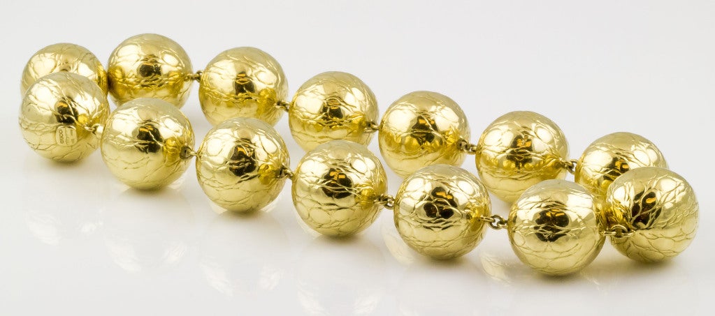 Schicke und ungewöhnliche Kugelkette aus 18 Karat Gelbgold mit Krokodilprägung von Gucci, ca. 1980er Jahre. Er besteht aus 14 einzelnen Kugeln, die alle die gleiche Textur haben. 
Punzierungen: Gucci, 750, Italien, 18K, italienische Prüfzeichen.