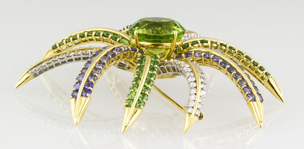 Chic and impressive 18K yellow gold, tanzanite, peridot and diamond brooch pin by Tiffany & Co. It features at its center an oval cut peridot of approx. 14.0cts , with approx. 5.0cts of very high grade round brilliant cut diamonds, approx. 4.5cts of