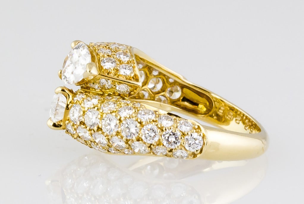 Elegant 18k yellow gold bypass ring with pave set diamonds and two pear shaped diamonds, by Cartier circa 1990s.  This ring is known as the 