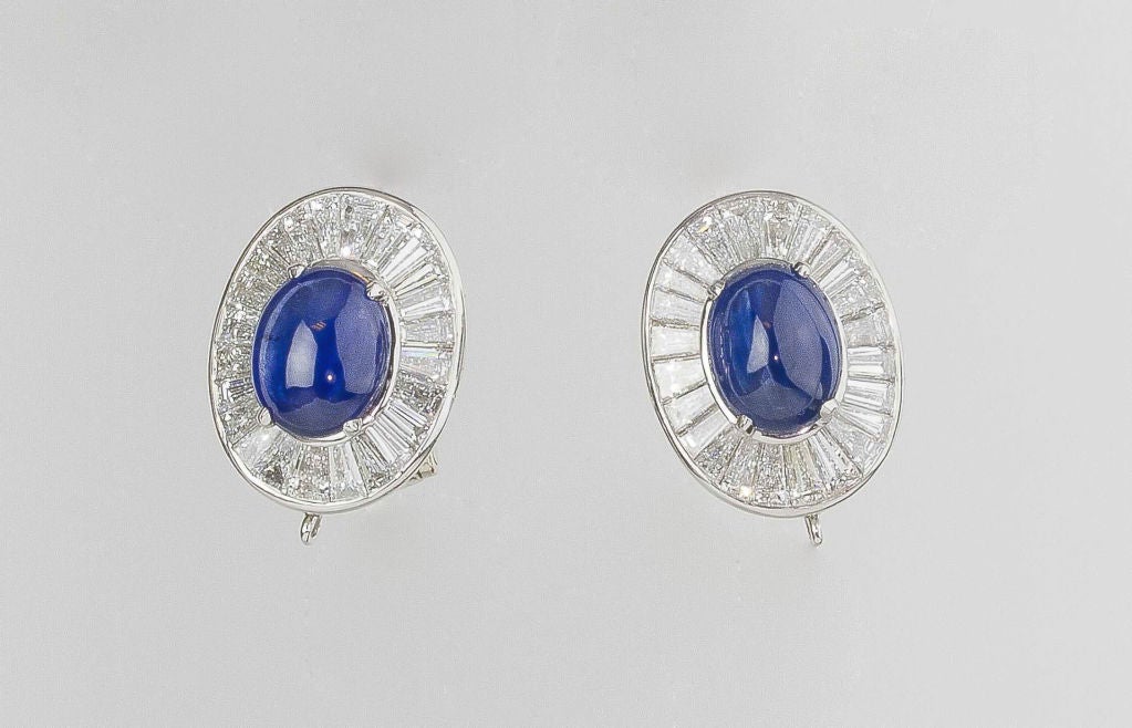 Impressive vintage platinum diamond and sapphire clip earrings by Van Cleef & Arpels. These feature two cabochon cut sapphires of high color and grade, with a total carat weight of 9.0cts. Surrounding the sapphires are high quality diamonds of a