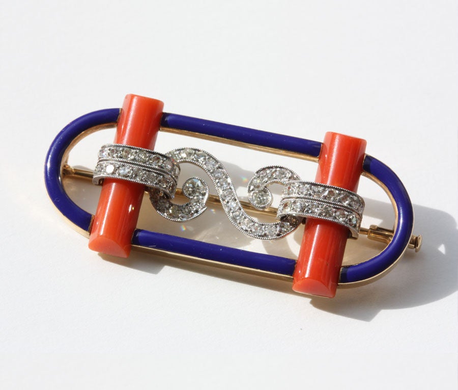 An 18 carat gold oval brooch of blue enamel on top of which are placed two coral panels connected by a ribbon of small single cut diamonds set in platinum, in original case, Master's mark for: Ernst Paltscho, Vienna, Austria, circa 1925

Ernst