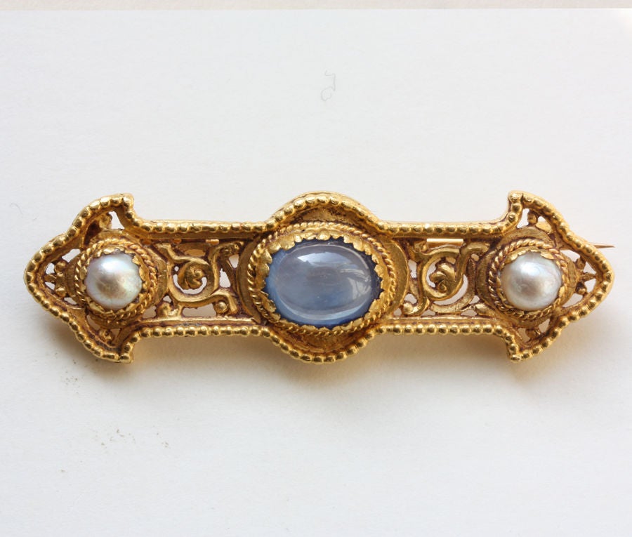 An 18 carat gold brooch in medieval style set with a cabochon cut star sapphire and two natural pearls, signed: Wiese for Jules or Louis Wiese, circa 1870, Paris.

Weight: 18 grams
Dimensions 5.3 x 1.5 cm.