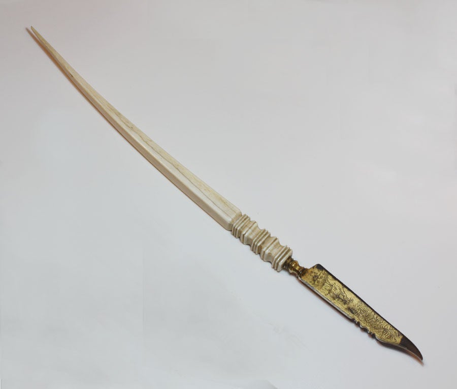 A pen knife of dagger form with etched and partly gilt decoration of foliate scrolls and a lady. Ivory handle, European, possibly Italian, end 16th century or early 17th century.