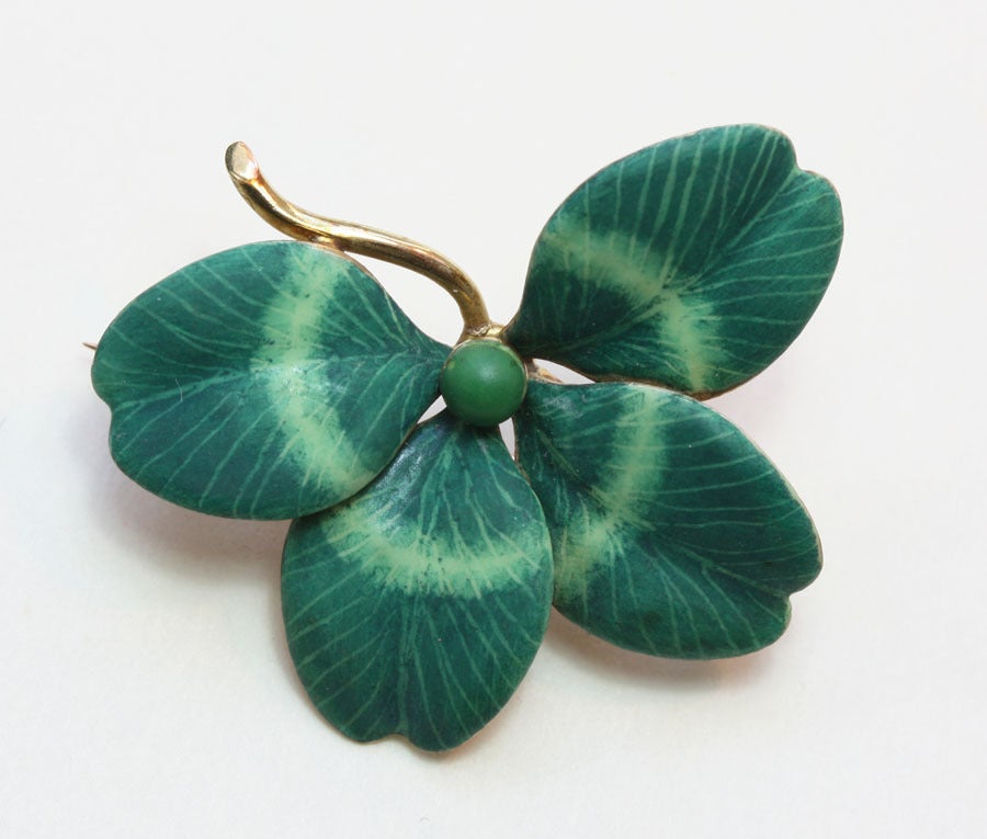 A 14 carat gold brooch in the shape of a naturalistically represented four leaf clover with green mat enamel and American masters mark, circa 1900, U.S.A.

weight: 5.3 grams
diameter: 3 cm.