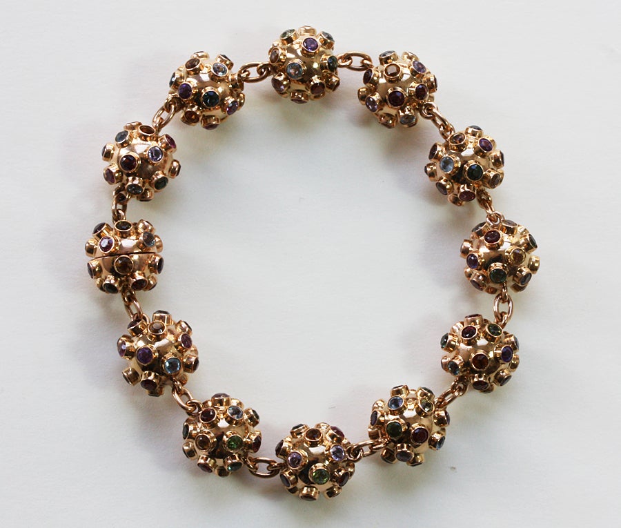 An 18 carat gold bracelet consisting of 12 spheres eac hset with many different colored gemstones, circa 1957.

weight: 25 grams
length: 18.5 cm.

In 1957, the Russian satellite â??Sputnikâ?? was launched, and with it a popular jewelry theme.