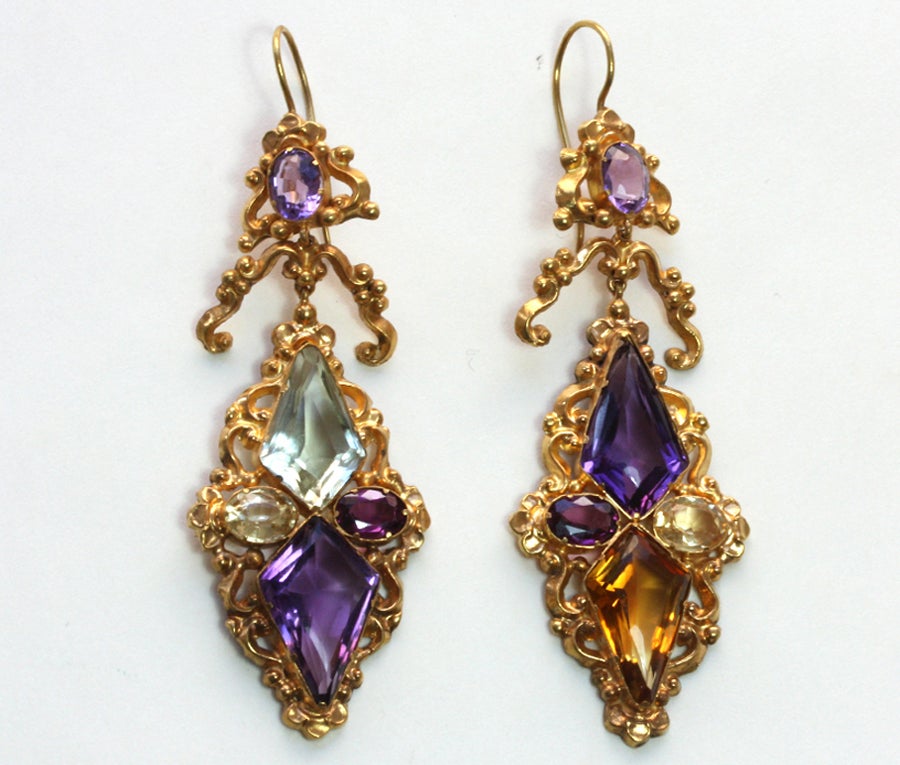 A superb pair of 18 carat gold harlequin earrings with light decorative repoussé goldwork set with oval and rhomboid cut gemstones such as amethysts, almandine garnets, citrine, topaz and the unsual green quartz, England, circa 1840.

length: 8.5