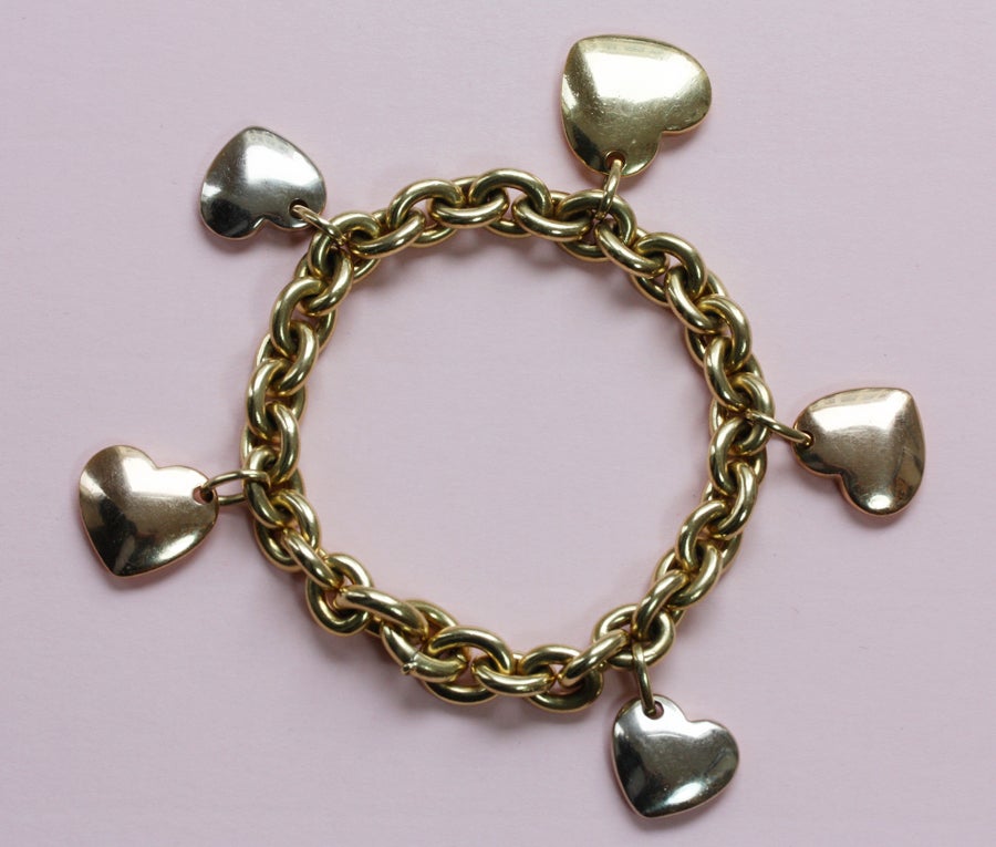 A heavy yellow gold charm bracelet with five hearts in yellow, white and pink gold, signed: Pomellato, circa 1980.

weight: 110.2 grams
length: 19.5 cm