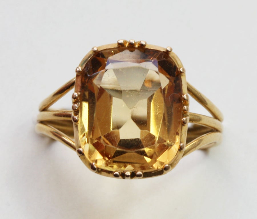 A gold ring set with a large yellow/brown topaz (circa 6 carats).

weight: 4.6 grams
ring size: 17.75 mm. 6 1/4 US.