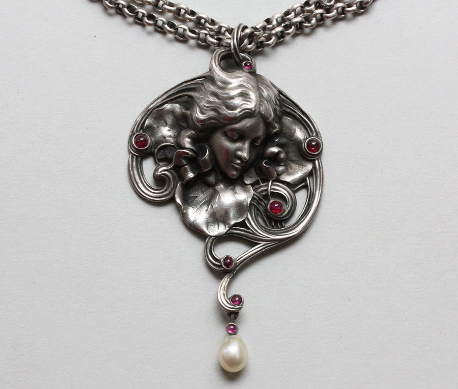 The ‘tête de femme’ was a popular motif in France around 1900. These ladies – combined with flowers – often symbolised themes, such as Sleep, Dream, or Desire. This dreamy example is one of the prettiest Art Nouveau girls’ heads. The large silver,