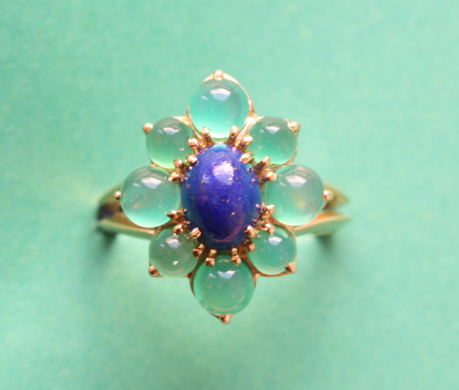 An 18 carat gold ring in the shape of a flower, with a cabochon cut lapis heart around which eight cabochon cut green stained agates, signed and numbered: Boucheron, Paris, 50901, circa 1960.

weight: 5.1 grams
ring size: 16.5 mm. 6 US.