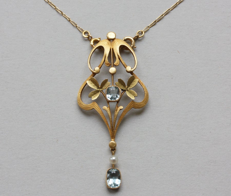 A lovely 18 carat gold Art Nouveau pendant decorated with clovers, two aquamarines (app. 1 carat), France, circa 1900.

weight: 7 grams
dimensions pendant: 5.6 x 2.5 cm
length chain: 43 cm.