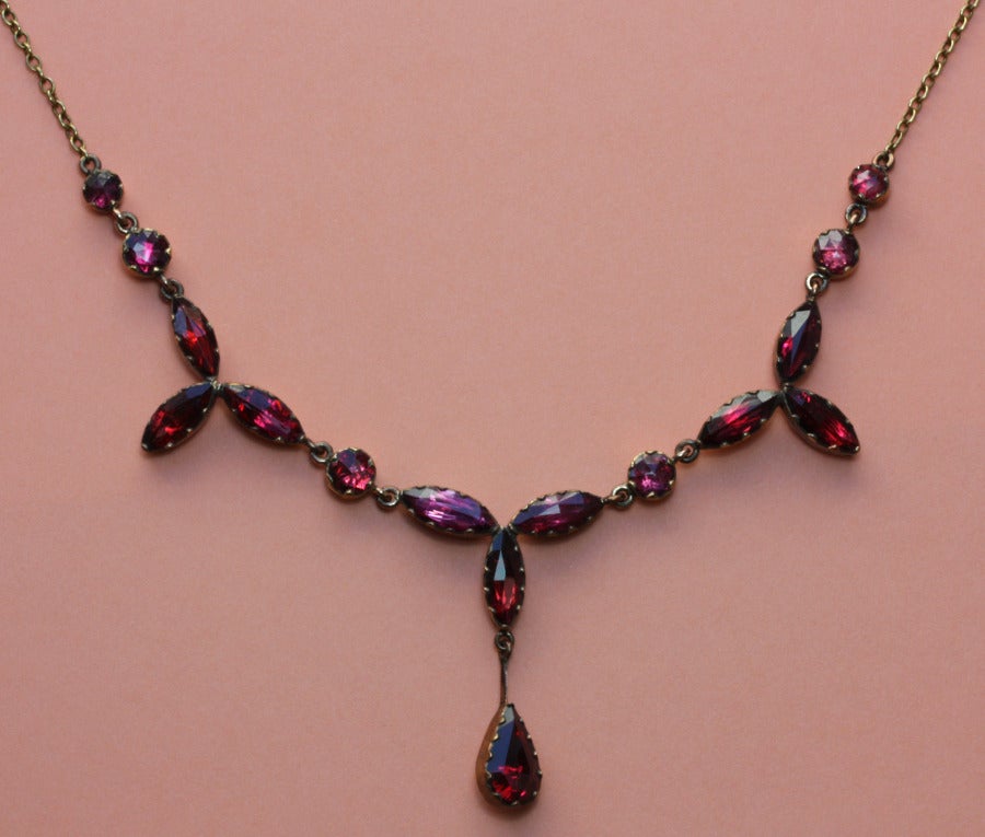 An 18 carat gold necklace with rose cut round and navette shaped rhodolite garnets, South of France, 19th century.

weight: 9.1 grams
length: 42 cm.