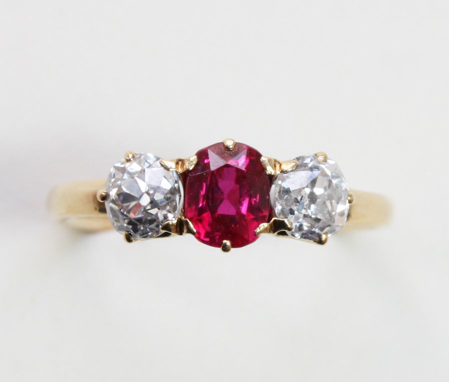 An exquisite 18 carat gold Edwardian ring set with two high old cut diamonds (each app. 0.4 carat, color F-G, vvs) with in the center a deep red natural unenhanced ruby (circa 0.6 carats), signed: Tiffany & Co., V.S., circa 1905.

weight: 2.5