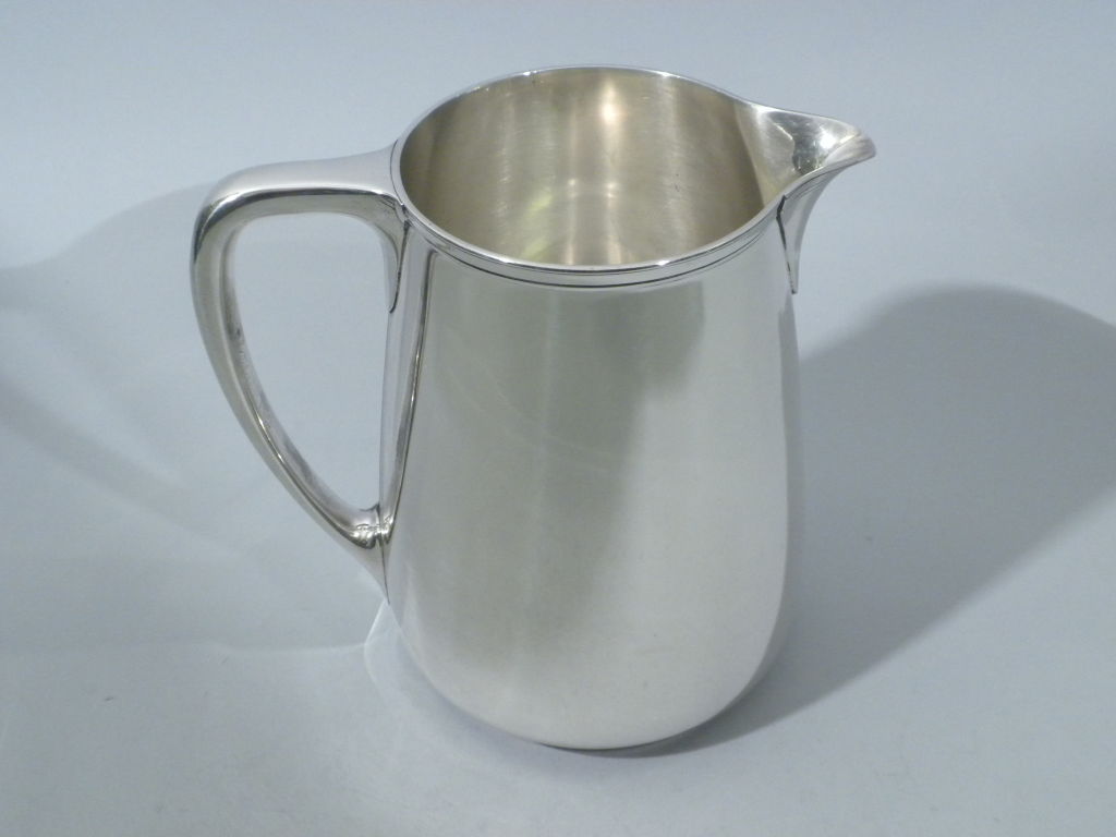 Elegant Art Deco Period Sterling Silver Water Pitcher made by Tiffany & Co., New York, Circa 1920.  The pitcher is hallmarked on the underside of the base with Tiffany's full complement of sterling marks, including the pattern #20210 and the liquid