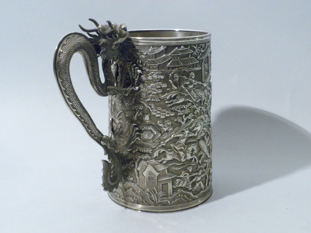 One of the best pieces of Chinese Export Silver we have had in our collection for a long time, this tankard was made by the renowned silversmith, LeeChing, Circa 1860.  The exterior of the tapered cylindrical tankard is repousse and chased with a