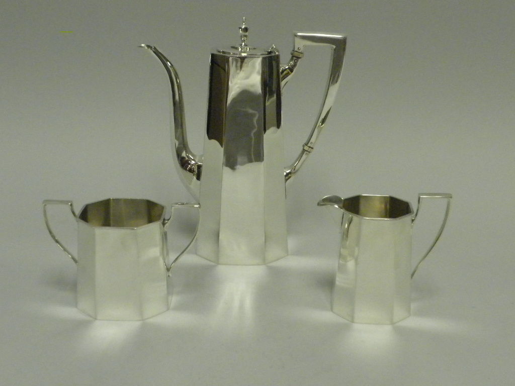 A three piece American Sterling Silver Demitasse and Coffee set designed in a clean, simple eight sided “Art Deco” style. Hallmarked Tiffany & Co., Sterling, #8500.  Very Good Condition.  Total Weight: 19.5 Troy Ounces. Height of Coffee Pot- 7 ¾ in.