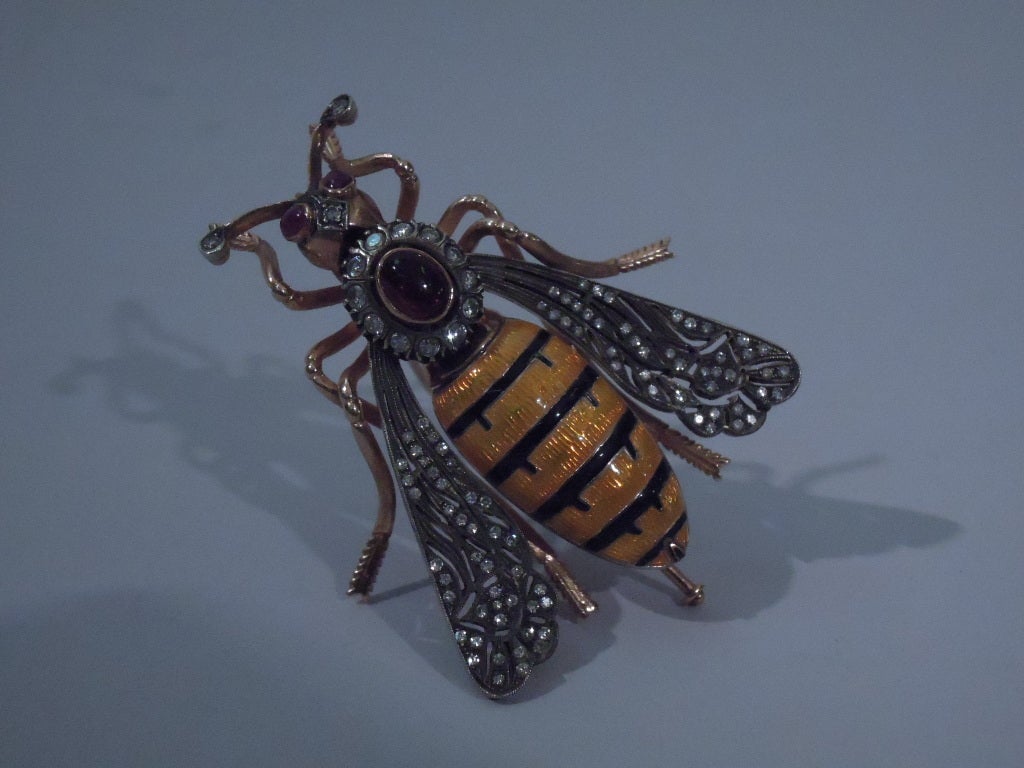 European bee-form brooch in 18 kt gold, enamel, diamonds, and garnets, ca. 1890. Black and yellow body with wings en tremble. Rose-cut diamonds on wings, body, and antennae. Three cabochon garnets of which two are eyes.
A bold design – perfect for