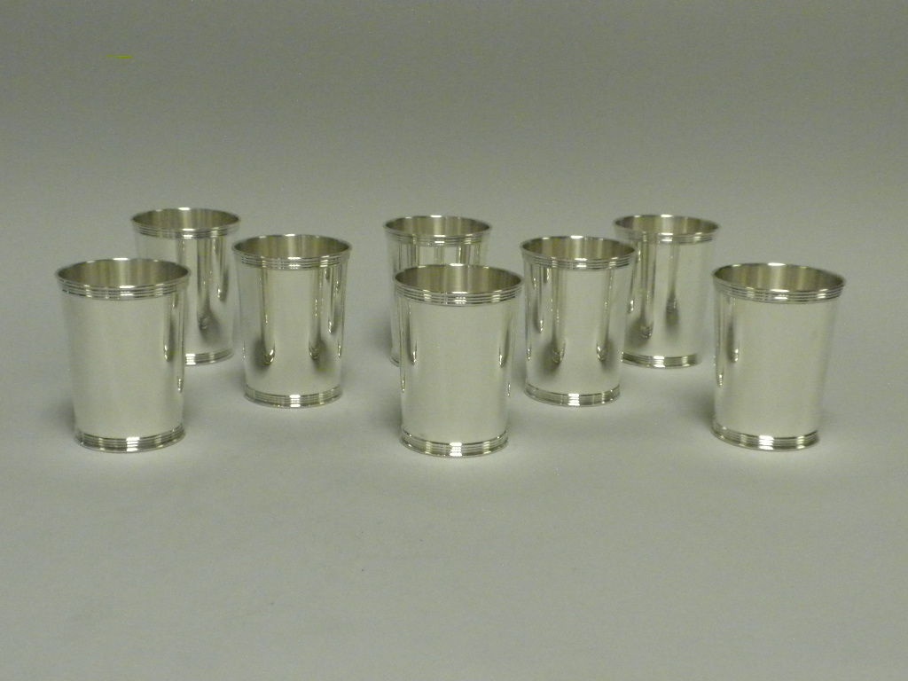This set of 8 sterling silver mint julep cups was made by Manchester Silver Co., Providence, RI in the banded pattern, #3759.  This set is a timeless and classic example of sterling silver mint julep cups made in the mid 20th century.  It is hard to