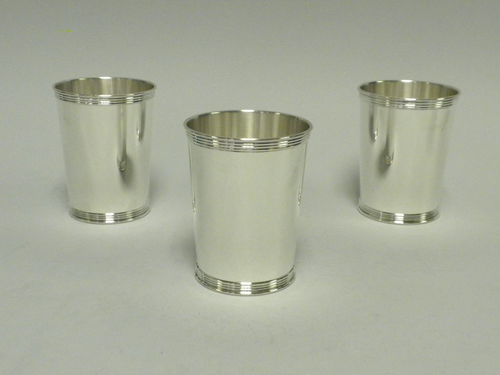 This set of 8 sterling silver mint julep cups was made by Manchester Silver Co., Providence, RI in the banded pattern, #3759.  This set is a timeless and classic example of sterling silver mint julep cups made in the mid 20th century.  It is hard to